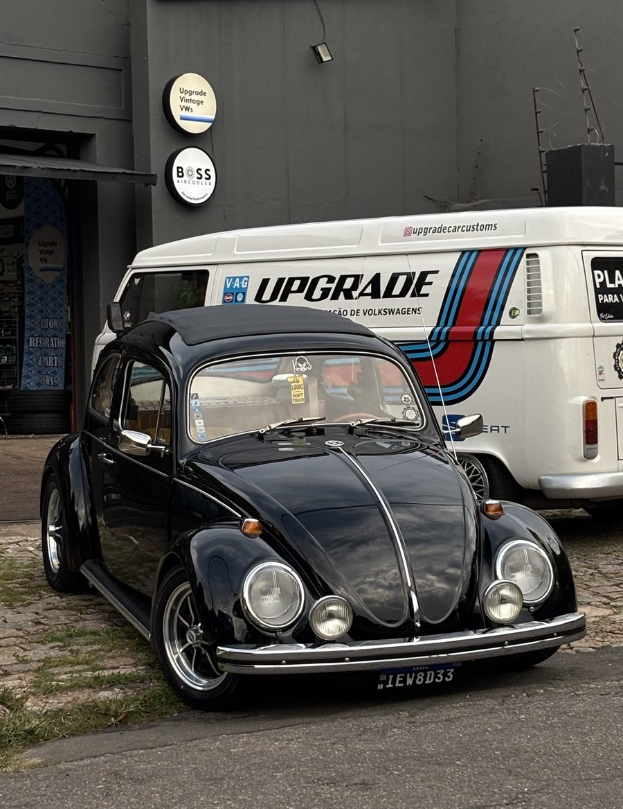 Fusca preto rebaixado em frente à oficina